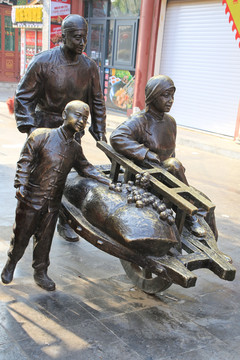 推独轮车的一家人铜雕