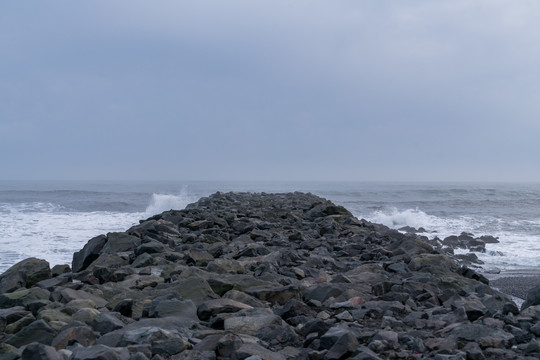 冰岛海边的黑色岩石堤坝背景