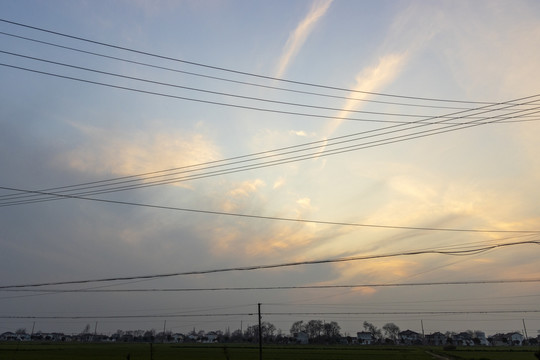 田野上空晚霞衬托的供电线