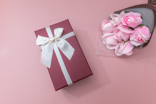粉色背景纸上一束花和礼盒
