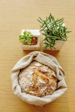 木桌上面包和绿色植物