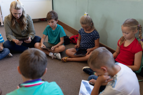 一群小学生在教室里使用平板电脑