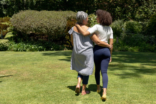 妇女和成年女儿在花园里拥抱