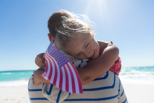 女孩和父亲一起举起美国国旗