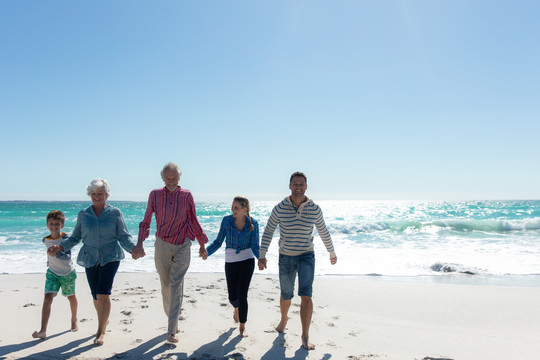 一个多代高加索人家庭站在海滩上