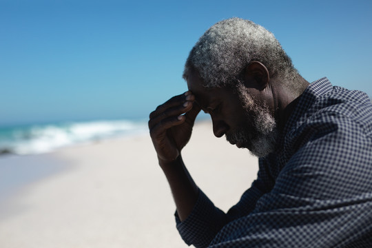 一位非洲裔美国老人坐在海滩上
