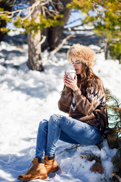 一位年轻女子正在享受冬天的雪