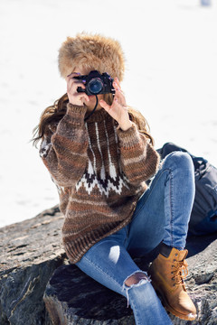 在雪山上拍照的年轻女子