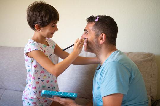 可爱的小女儿在给她父亲化妆