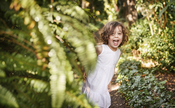 可爱的小女孩在热带花园里玩