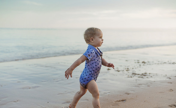 小可爱的男孩在海边散步