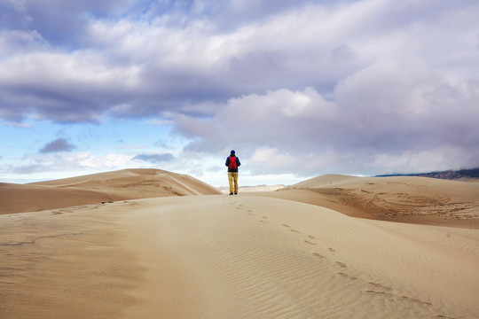 沙漠沙丘间的徒步旅行者