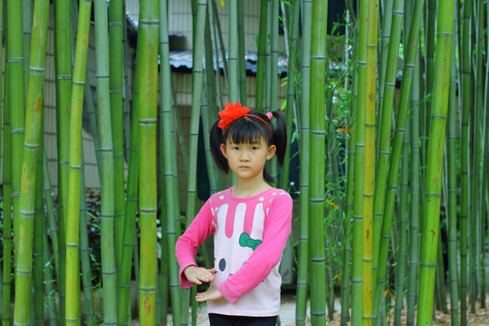 在竹林前玩的小女孩