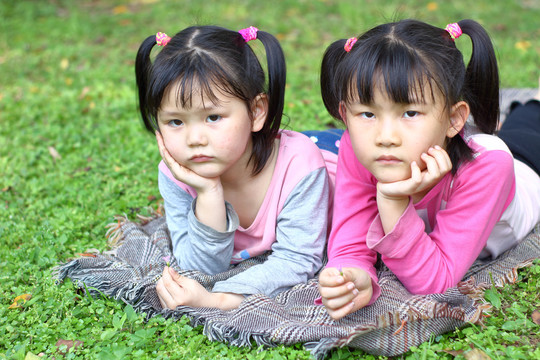 卧在草地上的两个小女孩