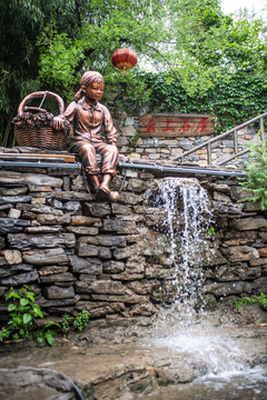 乡村小溪边的少女铜像