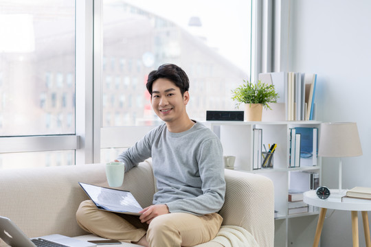 年轻男子在沙发上使用笔记本电脑