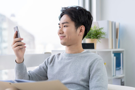 年轻男子坐在沙发上打电话