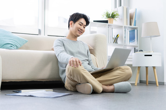 年轻男子在家使用笔记本电脑