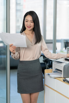 年轻商务女士使用打印机