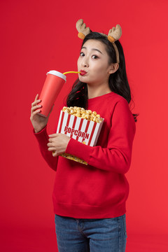 拿着爆米花和饮料的快乐女子