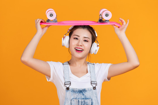棚拍拿着滑板的年轻女子