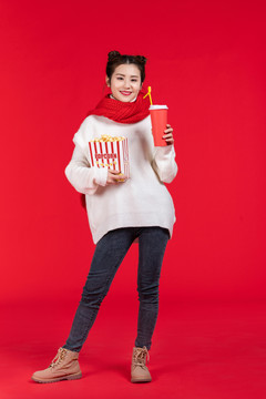 拿着爆米花和饮料的快乐女子