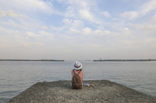 背着背包在海边欣赏风景的女人