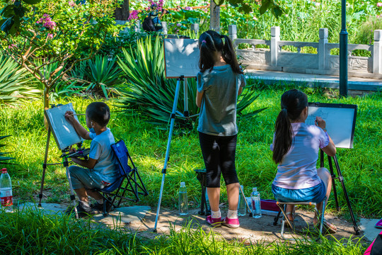假日公园里写生画画的小孩