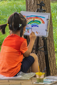 假日公园里写生画画的小女孩