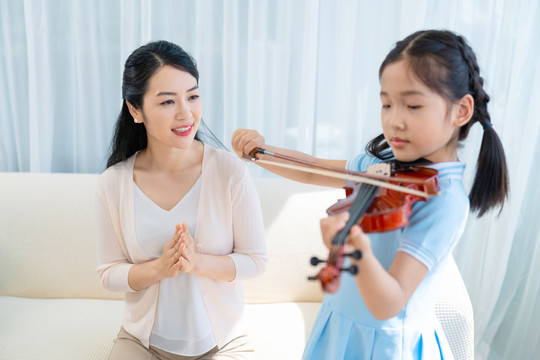 女儿给妈妈演奏小提琴
