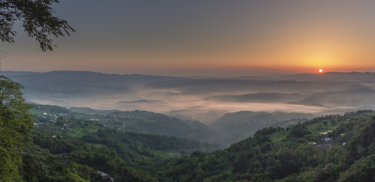 清晨日出薄雾缭绕的田野与山脉