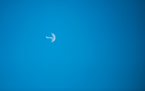 月亮前飞行的飞机