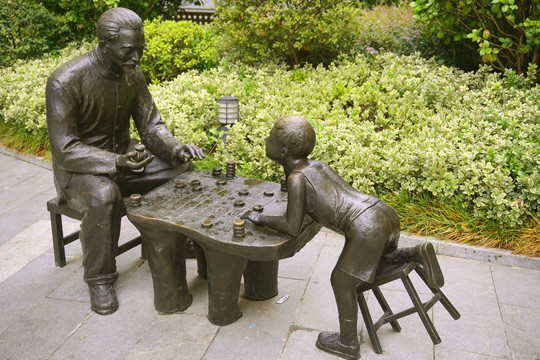 下象棋的老人儿童塑像