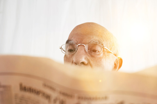 阅读财经报纸的老年人