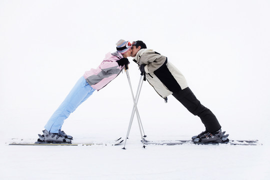 在山上亲吻的滑雪者