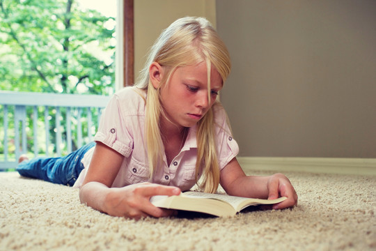 躺在地毯上看书的女孩
