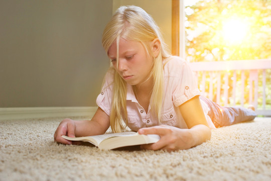 躺在地毯上看书的女孩