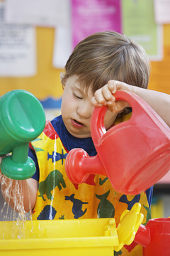 幼儿园玩水罐的男孩