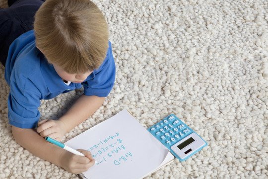 地毯上做作业的小男孩