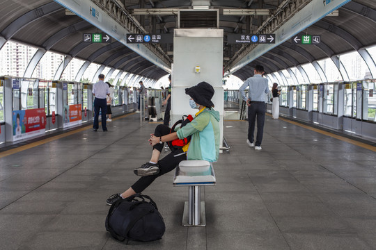 地铁站翘腿等车的女人