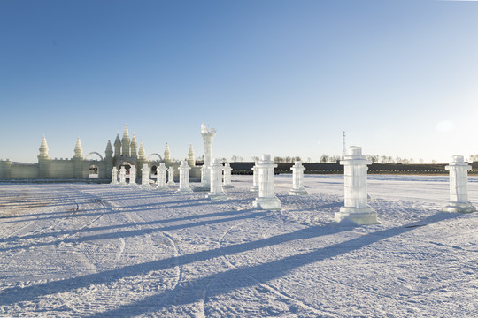 夕阳下雪原上晶莹剔透的冰雕建筑