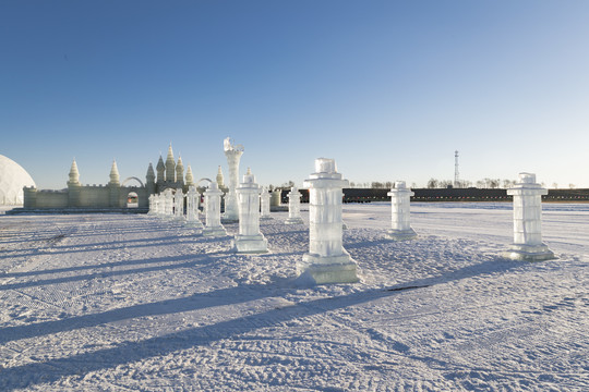 夕阳下雪原上晶莹剔透的冰雕建筑