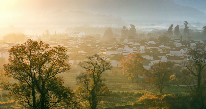 宽幅斜阳晨雾满山村