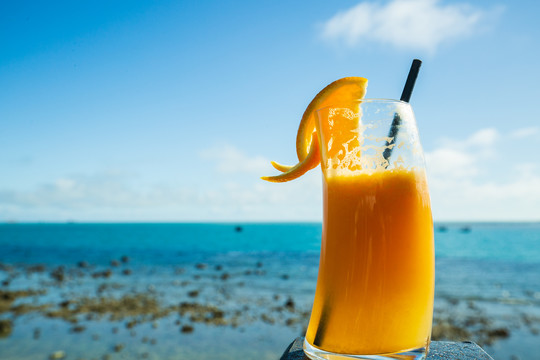 大海边喝橙汁饮料