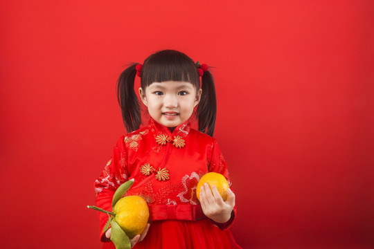 女孩开心拿着橘子迎接春节