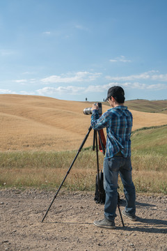 一名男性在使用三脚架相机拍照