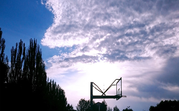 篮球场上阳光刺破白云的蓝天