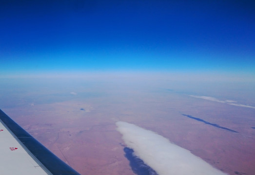 在飞机上俯瞰蓝天中的巨型白云