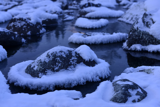 冬季河流中石头上的积雪