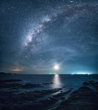 热带海岛海边夜晚的星空银河与月